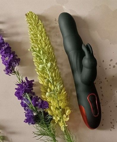 A toy bunny next to flowersDescription automatically generated